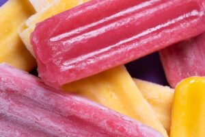 Variety of refreshing summer treats including ice cream, popsicles, fruit snacks, and cold drinks for wholesale customers