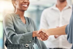 An INW account representative shaking hands with an independent convenience store owner in Oklahoma, representing a true wholesale partnership.