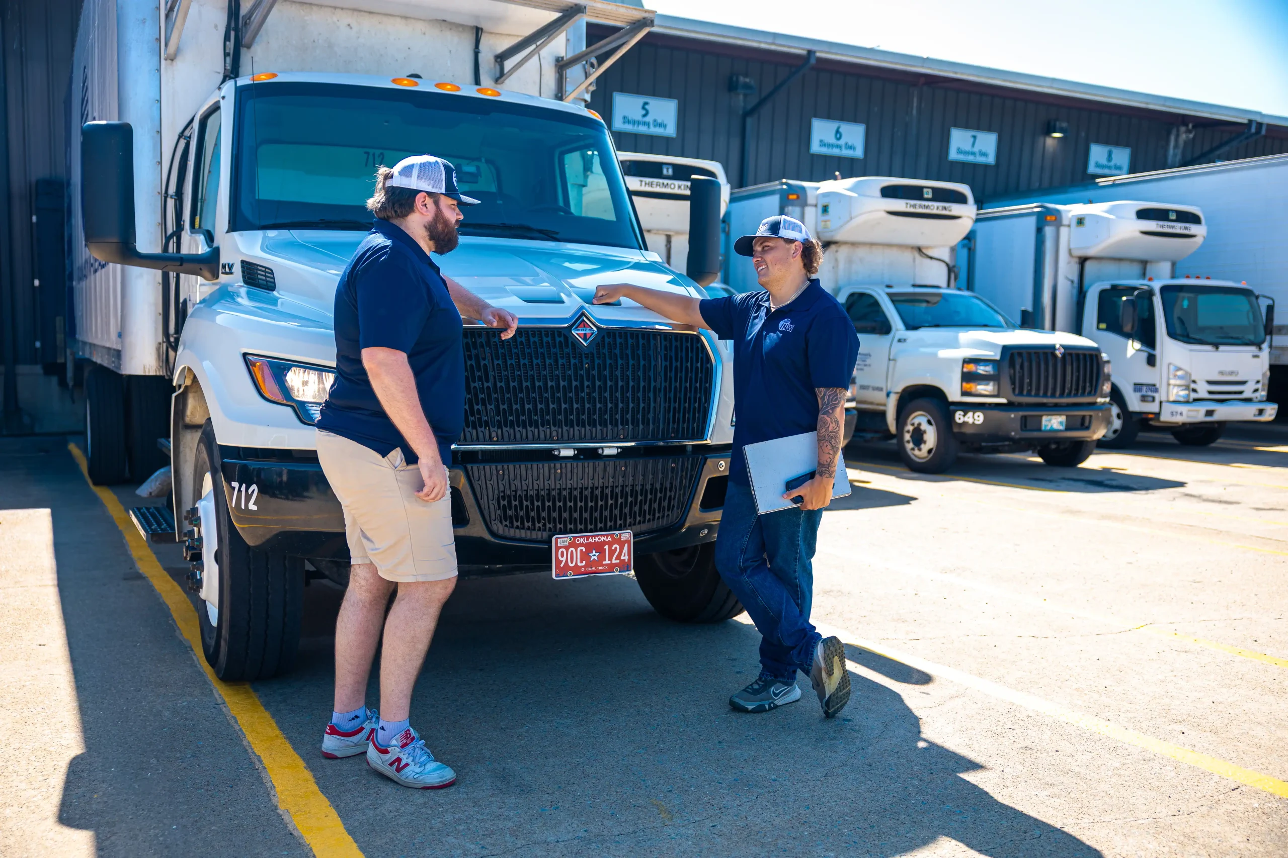 Two INW truckers talking in front of an INW Truck.