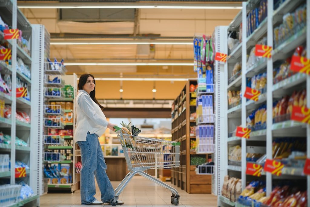 Pregnant woman buying goods in a grocery store.